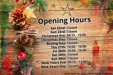 A wooden tabletop, adorned with festive oddities, with colour stained images and the opening hours imprinted upon it.