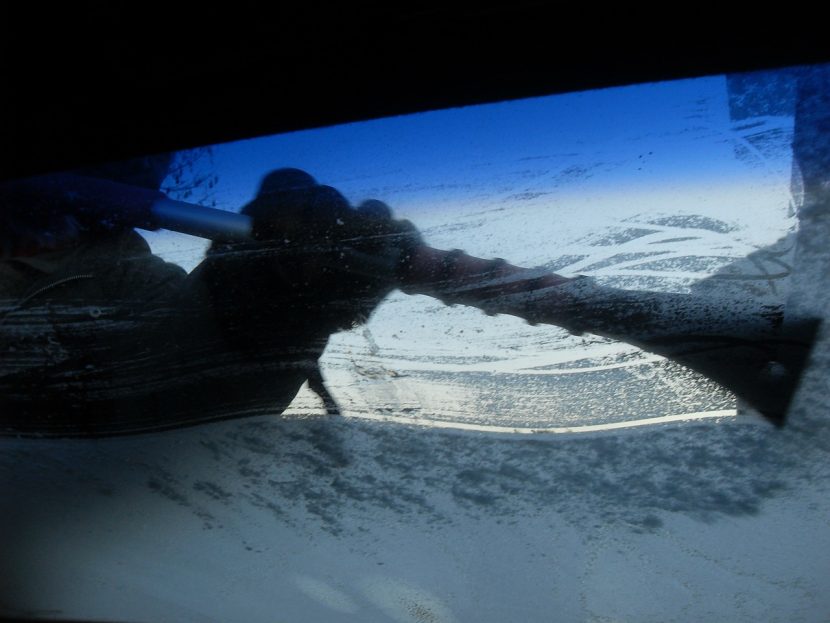 icy car windshield being scraped clear